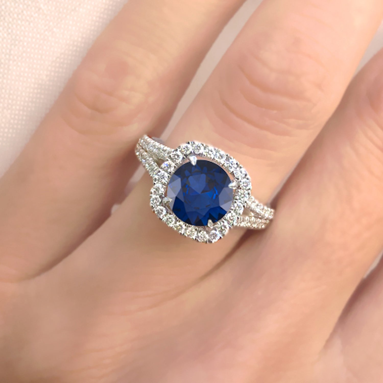 טבעת אירוסין דיפ בלו מעבדה – ספיר כחול מעבדה בחיתוך עגול
 מוקף יהלומים