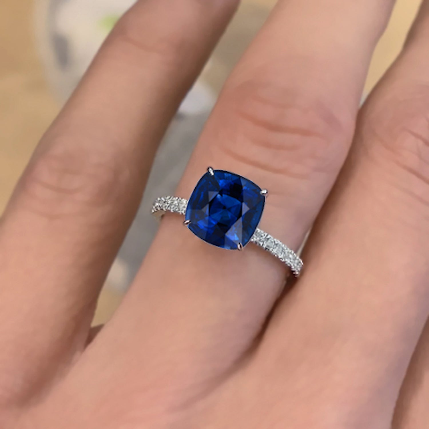 טבעת אירוסין נייבי מעבדה – אבן ספיר כחולה בחיתוך קושן ושיבוץ יהלומי צד