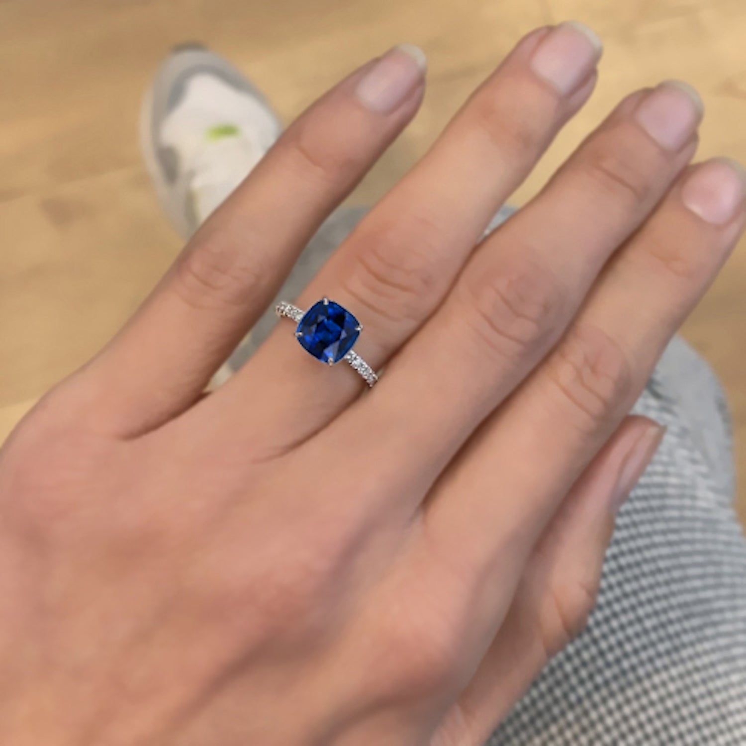 טבעת אירוסין נייבי מעבדה – ספיר כחול עמוק בשיבוץ עדין על זהב לבן, מבט על היד